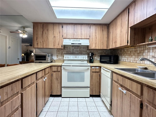 kitchen featuring light tile patterned floors, white appliances, tasteful backsplash, and sink