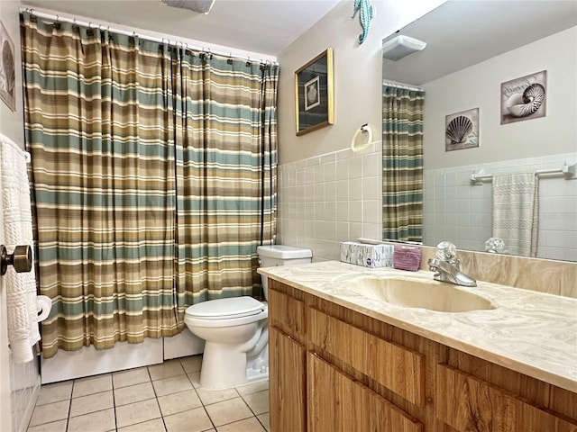 bathroom with tile patterned flooring, vanity, toilet, and tile walls