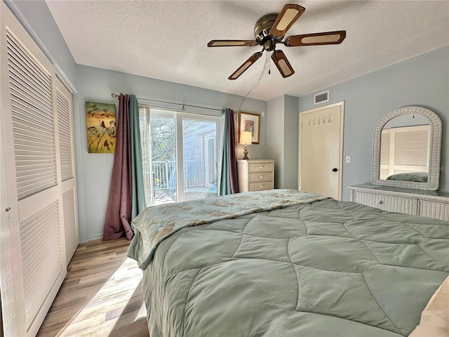 bedroom with light wood-type flooring, a textured ceiling, access to outside, ceiling fan, and a closet