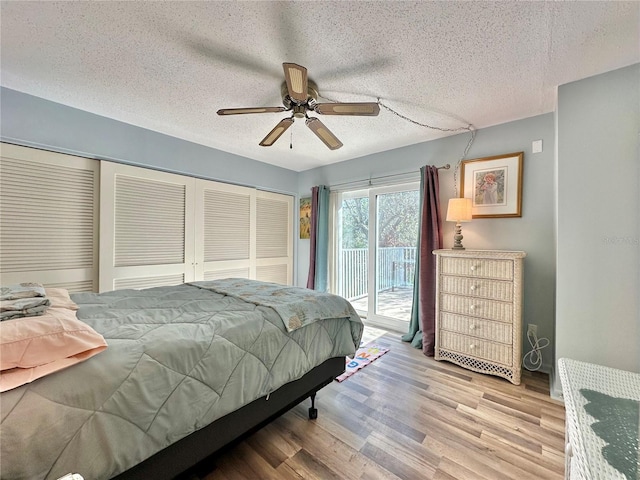 bedroom featuring a textured ceiling, access to outside, ceiling fan, light hardwood / wood-style floors, and a closet