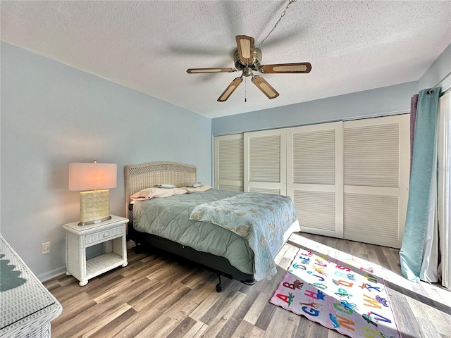 bedroom featuring ceiling fan, a closet, wood-type flooring, and a textured ceiling