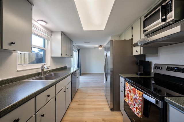 kitchen featuring sink, white cabinetry, ceiling fan, stainless steel appliances, and light hardwood / wood-style floors