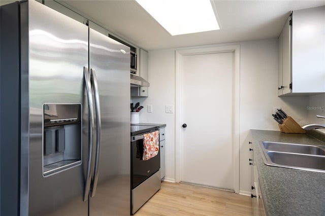 kitchen with white cabinetry, appliances with stainless steel finishes, sink, and light hardwood / wood-style flooring