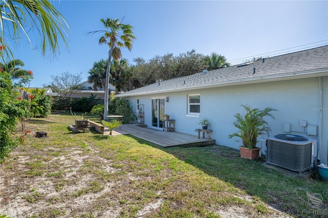 rear view of property with a wooden deck, cooling unit, and a lawn