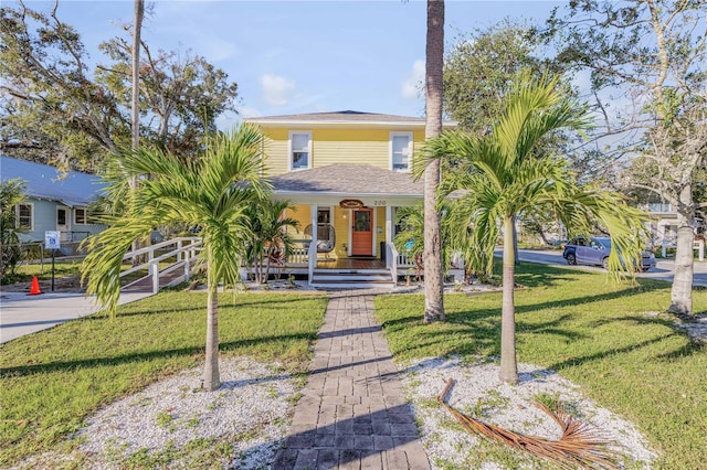 view of front of home with covered porch and a front lawn