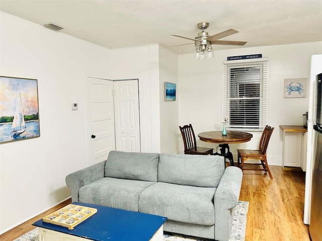 living room with ceiling fan and light hardwood / wood-style floors