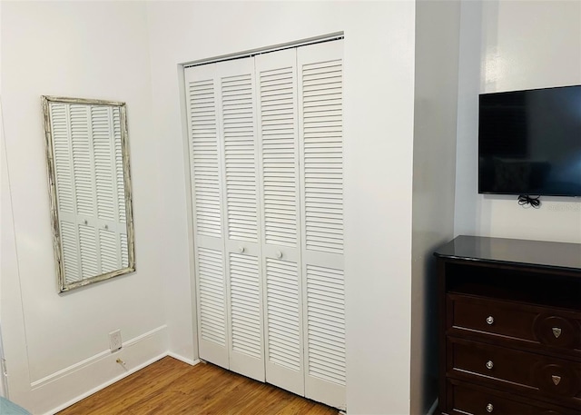 bedroom with light hardwood / wood-style floors and a closet