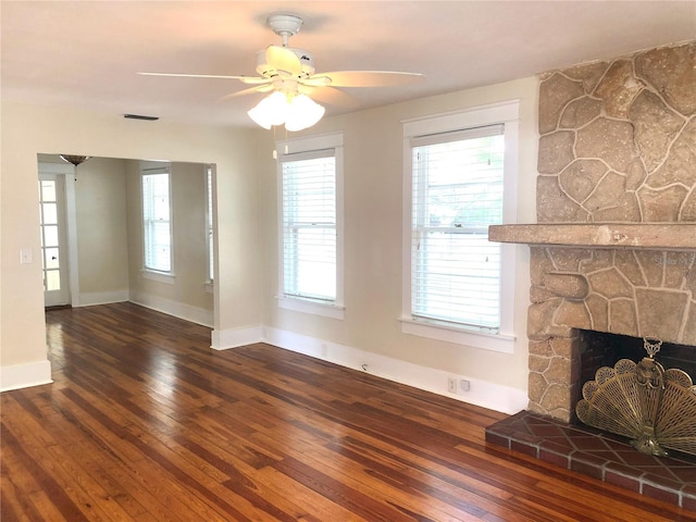 unfurnished living room featuring a stone fireplace, ceiling fan, and hardwood / wood-style floors