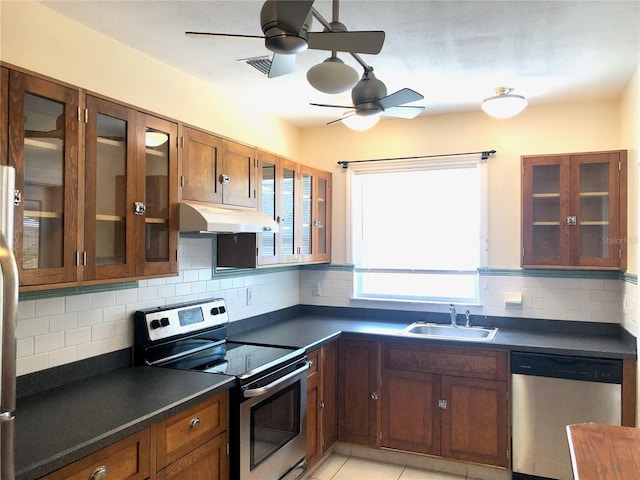 kitchen with ceiling fan, sink, stainless steel appliances, backsplash, and light tile patterned floors