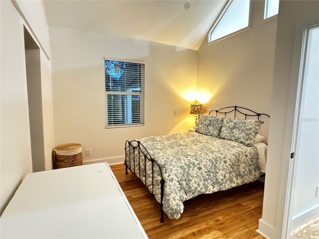 bedroom with hardwood / wood-style flooring and vaulted ceiling