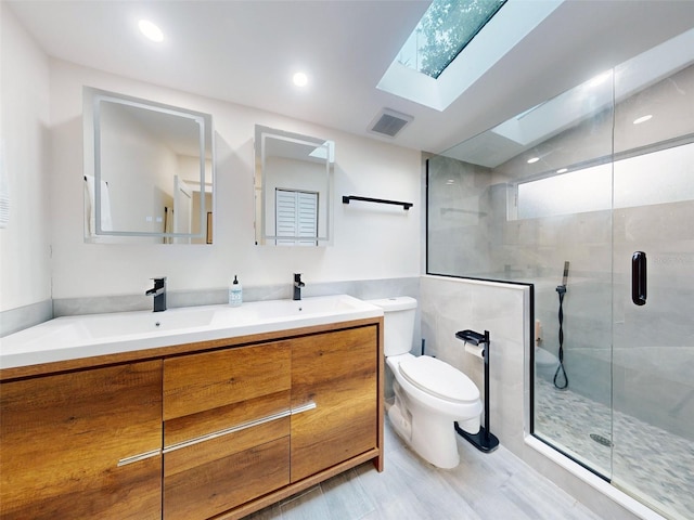 bathroom with toilet, an enclosed shower, vanity, and a skylight