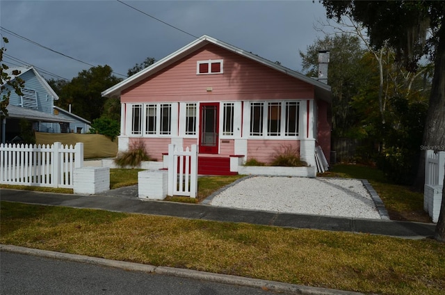 bungalow featuring a front lawn