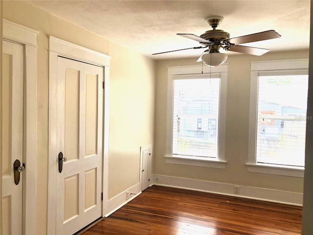 empty room with ceiling fan and dark hardwood / wood-style floors