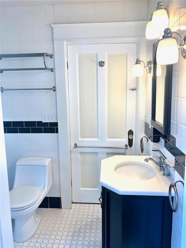 bathroom with tile patterned floors, vanity, toilet, and tile walls