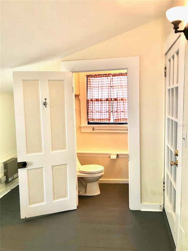 bathroom featuring hardwood / wood-style floors, toilet, and lofted ceiling