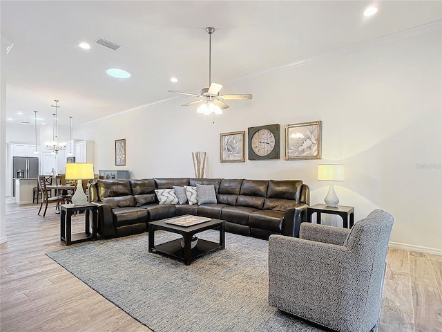 living area featuring light wood-style flooring, visible vents, and crown molding