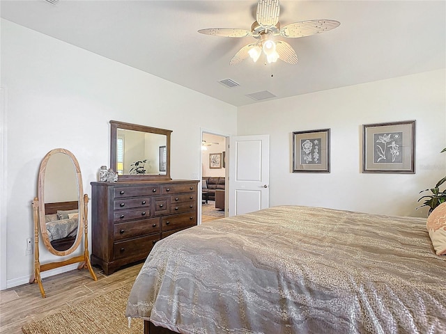 bedroom with ceiling fan, light wood finished floors, and visible vents