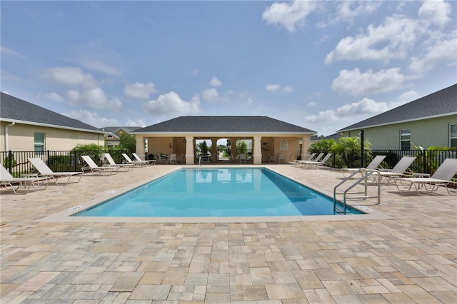 community pool featuring fence and a patio