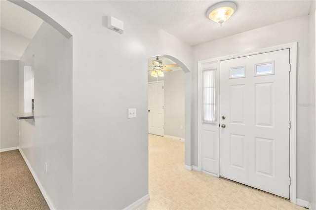 entrance foyer with ceiling fan and a textured ceiling