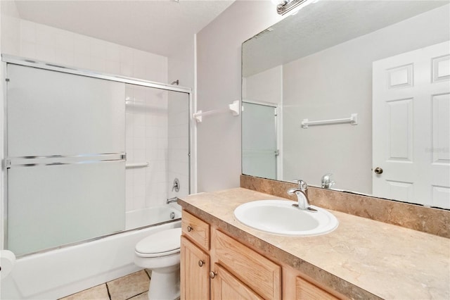 full bathroom featuring tile patterned floors, vanity, bath / shower combo with glass door, and toilet