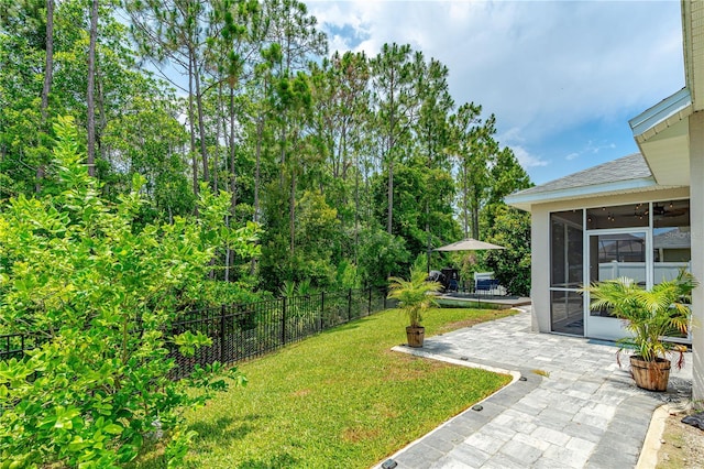 view of yard with a sunroom and a patio