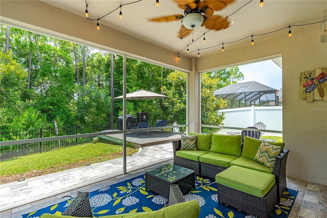 sunroom / solarium featuring ceiling fan