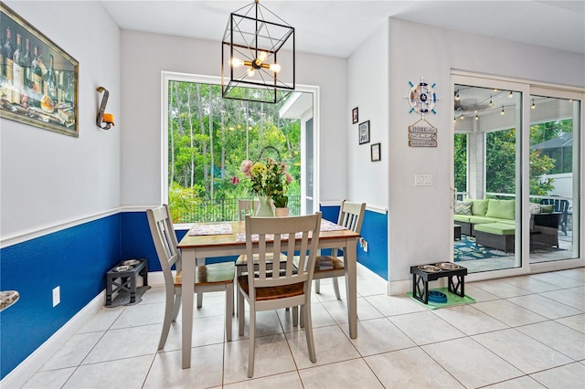 dining space with light tile patterned floors, an inviting chandelier, and a wealth of natural light