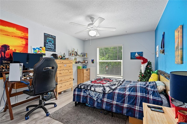 bedroom featuring wood-type flooring, a textured ceiling, and ceiling fan