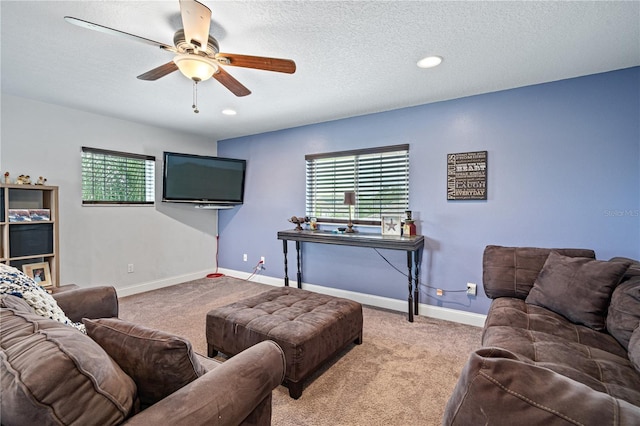 carpeted living room with ceiling fan and a textured ceiling