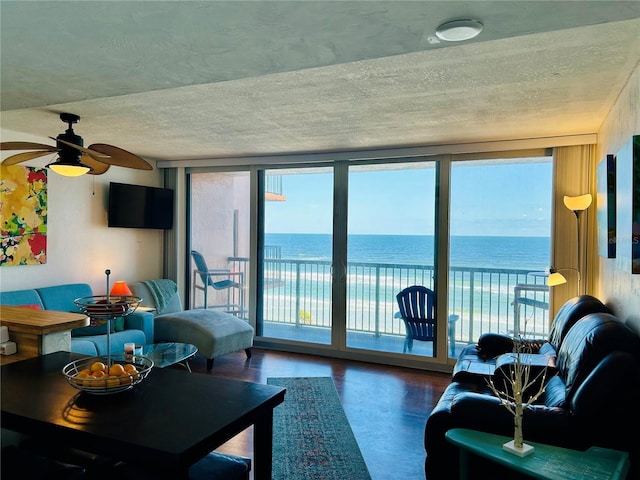 living room featuring floor to ceiling windows, concrete floors, a wealth of natural light, and ceiling fan