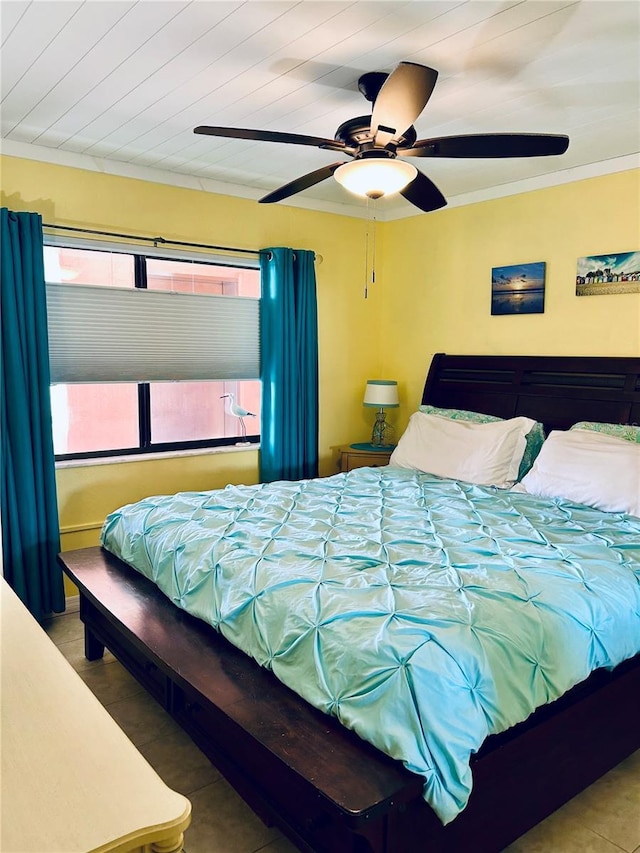 tiled bedroom with ceiling fan and crown molding