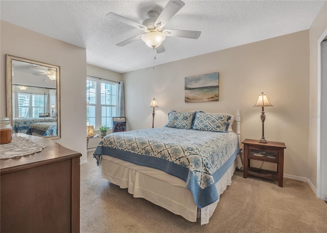 carpeted bedroom featuring ceiling fan and a textured ceiling