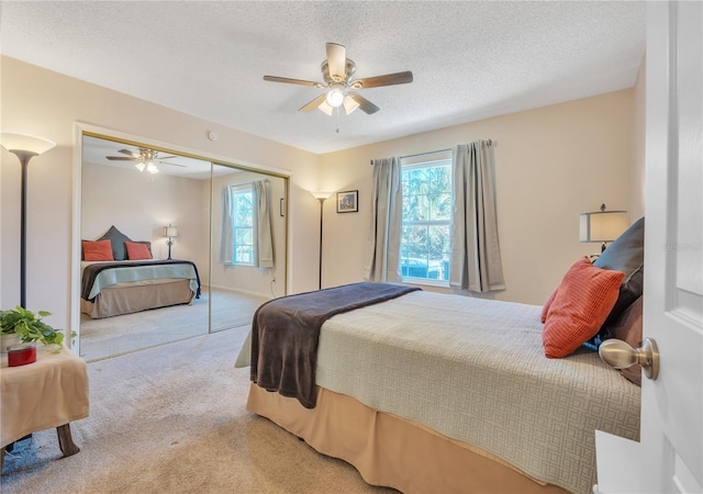 carpeted bedroom featuring ceiling fan, a textured ceiling, and a closet