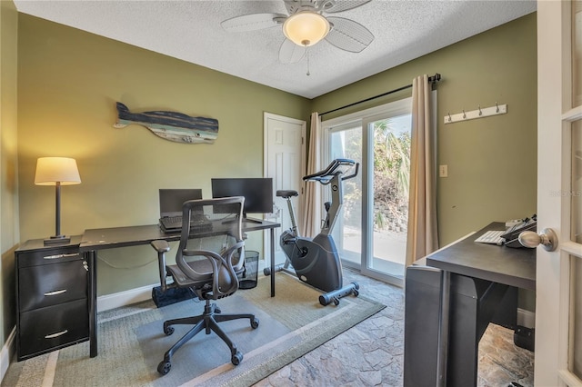 carpeted office with a textured ceiling and ceiling fan