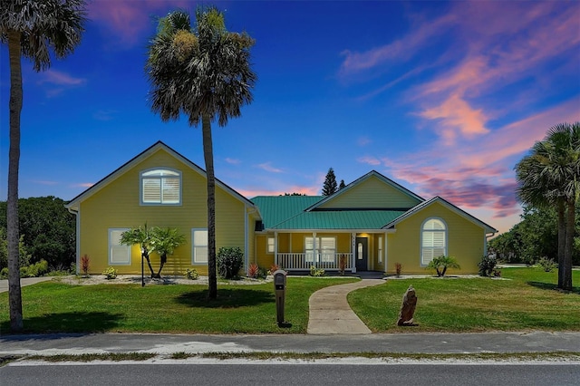 view of front of home featuring covered porch and a yard