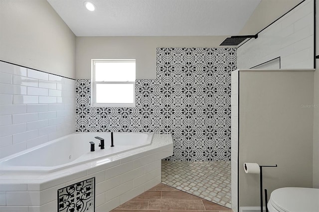 bathroom featuring hardwood / wood-style flooring, toilet, a textured ceiling, and shower with separate bathtub