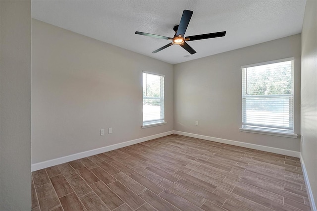 empty room with a textured ceiling, light hardwood / wood-style floors, and ceiling fan