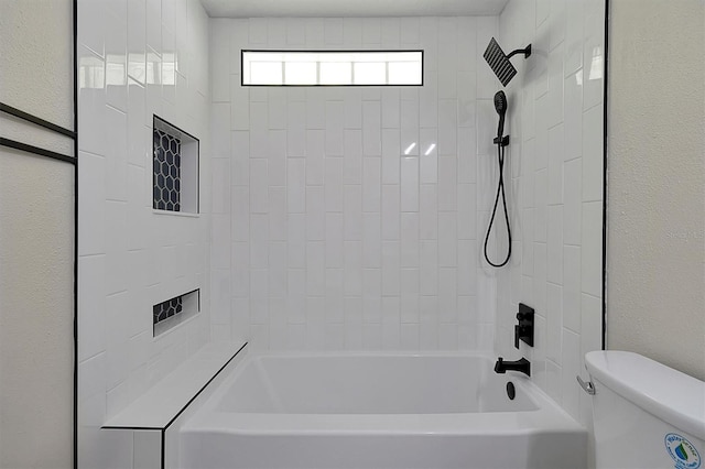 bathroom featuring toilet and tiled shower / bath