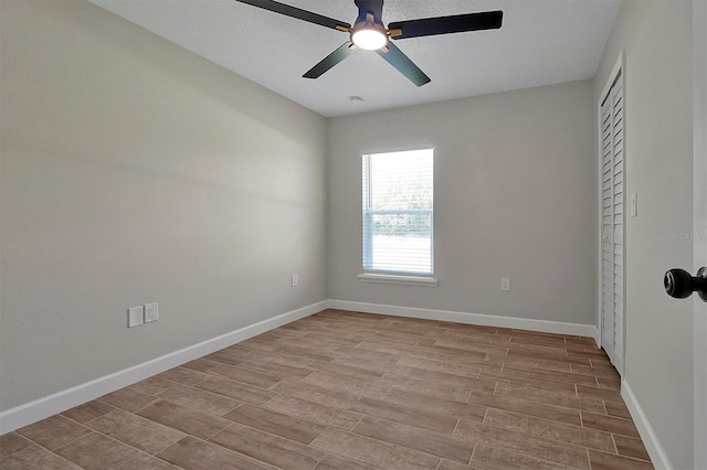 empty room featuring ceiling fan, light hardwood / wood-style floors, and a textured ceiling