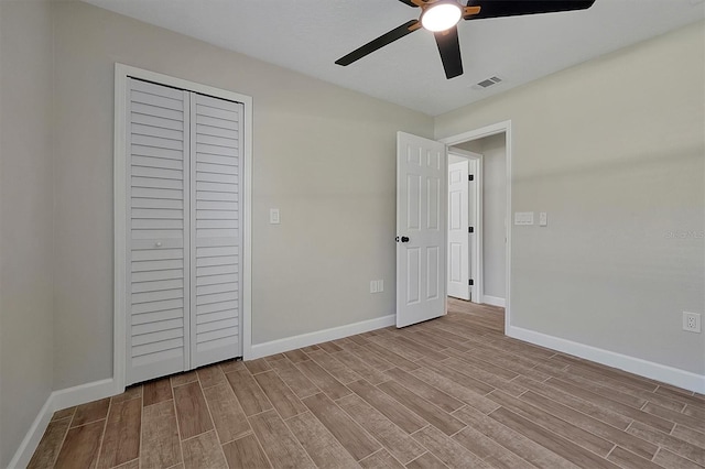 unfurnished bedroom featuring ceiling fan, a closet, and light wood-type flooring