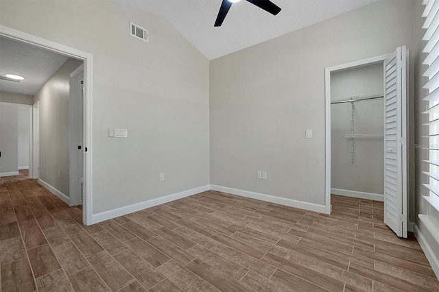 unfurnished bedroom featuring a closet, light hardwood / wood-style floors, ceiling fan, and lofted ceiling