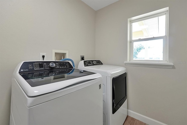 laundry area with washing machine and dryer and wood-type flooring