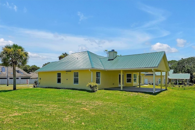 rear view of property featuring ceiling fan, a yard, and a patio