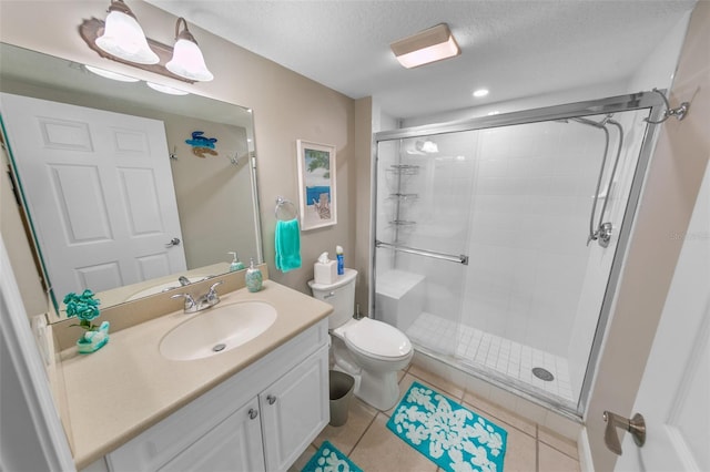 bathroom featuring tile patterned flooring, a textured ceiling, toilet, vanity, and a shower with shower door