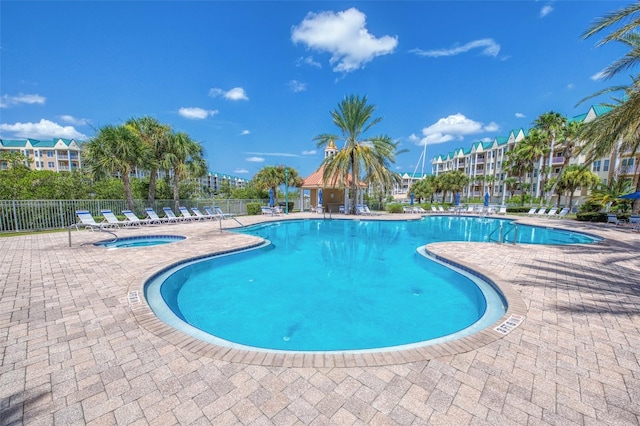 view of swimming pool featuring a patio area and a hot tub