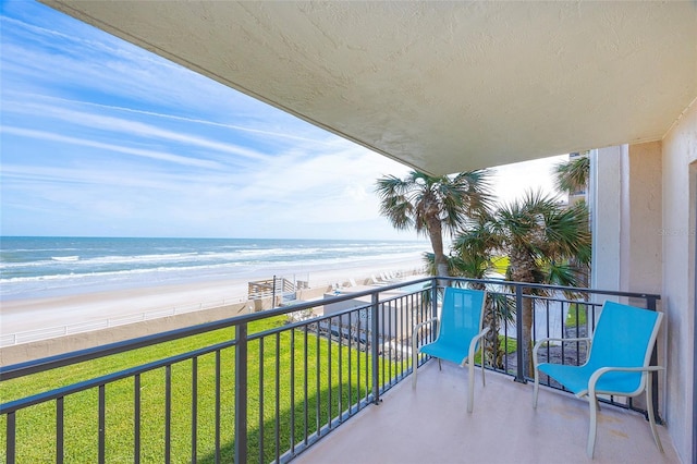 balcony featuring a beach view and a water view