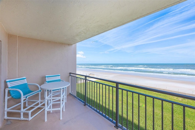 balcony featuring a beach view and a water view