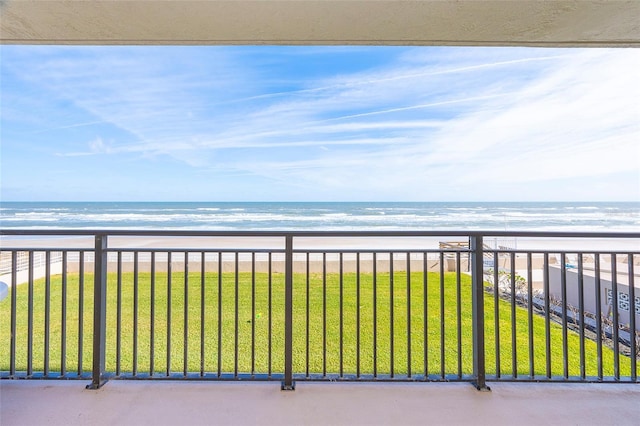 balcony with a water view and a view of the beach