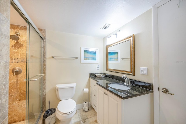 bathroom with vanity, toilet, and a shower with door