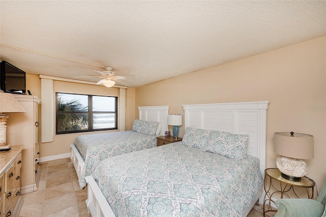 bedroom with ceiling fan and a textured ceiling